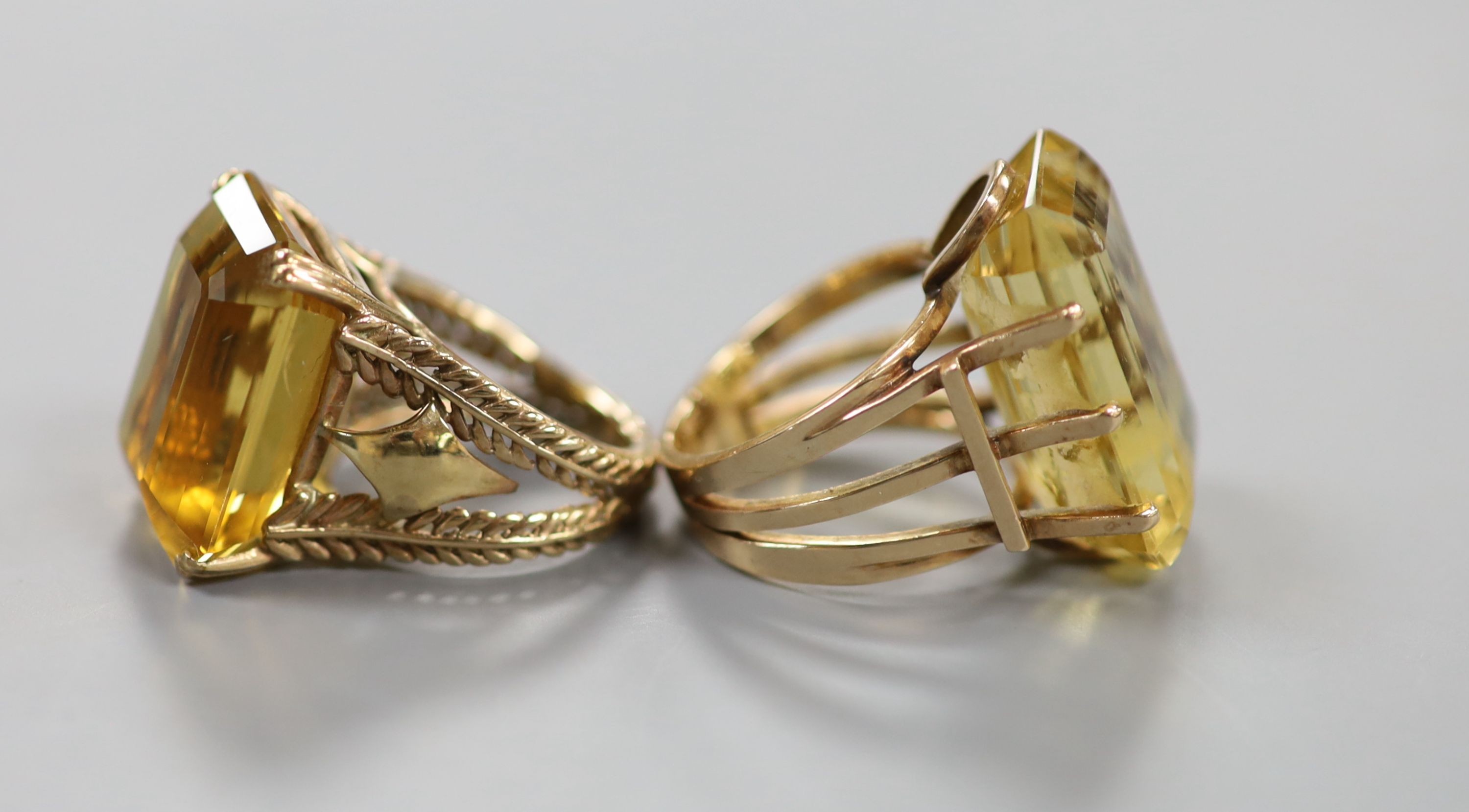 Two yellow metal and citrine set dress rings, one faintly marked 9ct, sizes L/M & P, gross weight 27 grams.